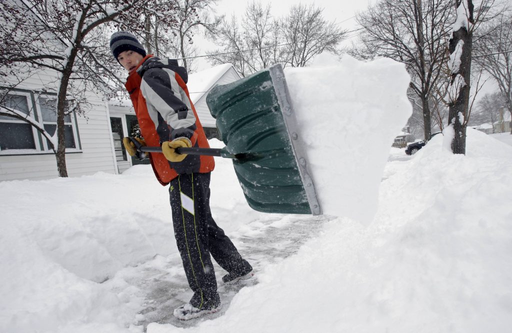 Mike Flynn shovels snow Tuesday, March 5, 2013, in Minneapolis as a winter storm dumped snow on much of the state. Tens of thousands of Minnesota students got a day off Tuesday as the second day of a slow-moving snowstorm made travel difficult across much of the region.  (AP Photo/Jim Mone)